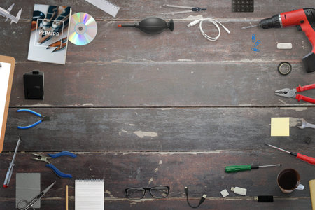 Repair tools on wooden desk. Free space in middle for text. Craft surface. Top view.
