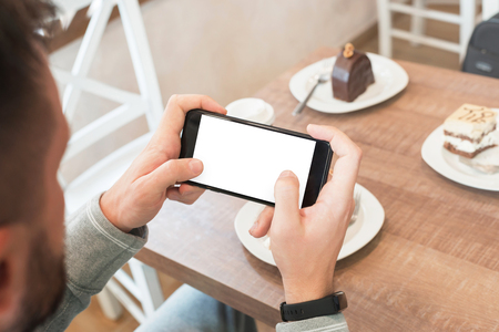 Play game on mobile phone with isolated screen for design app presentation.の写真素材