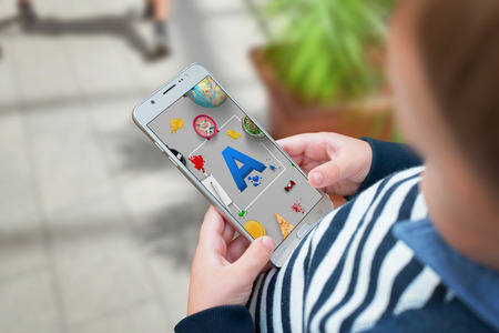 Boy agrees letters on a mobile app and learn through the game.の写真素材