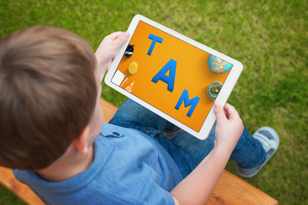 Child uses a tablet to learn letters. A creative app for playing and developing children ability.の写真素材