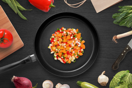 Frying pieces of vegetables in a pan. Preparing ingredients for head dish. Vegetarian cuisine. Top view.の写真素材