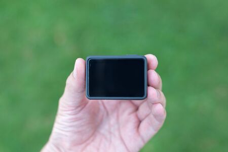 Action camera in hand close-up. Blank display, screen mockup.の写真素材