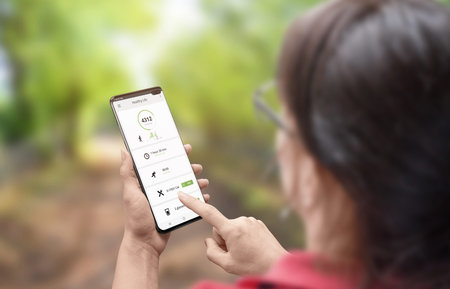Woman use app for measure daily steps. Walking nature concept.