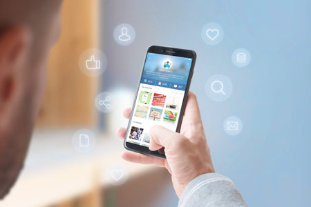 Man shares photos and videos with his friends on social network concept. Phone surrounded with...