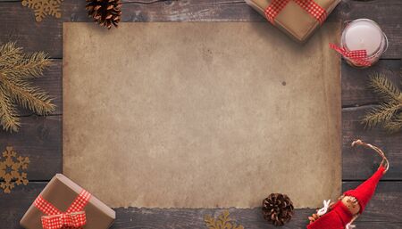 Blank old vintage paper surrounded by Christmas decorations and gifts. Greeting card concept. Mockup, top view, flat lay composition.の写真素材