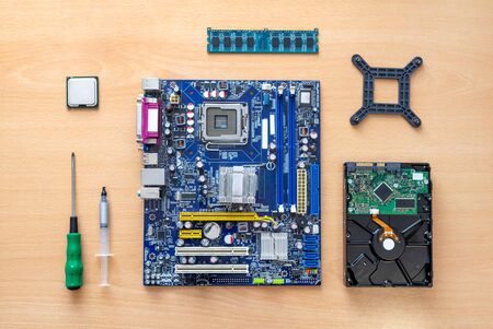 Motherboard, processor, memory, hard drive, screwdriver and thermal paste on the table. The concept of assembling computer. Top view, flat lay.の写真素材