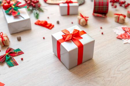 Gift on table surrounded by decorations and gifts. Concept of Christmas preparation of gifts. Close-up.の写真素材