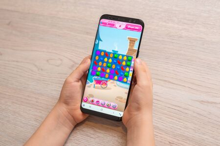 Sarajevo, Bosnia and Herzegovina - November 30, 2019: Candy Crush Saga puzzle video game on modern smart phone in kid hands close-upのeditorial素材