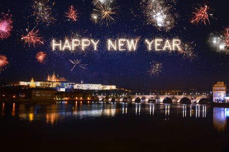 Happy New Year written with sparkle fireworks on night sky above Pragueの写真素材