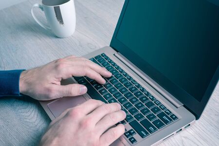 Working from home on a laptop. Detail of the hands typing on the keyboard. Concept of self-employed and teleworkingの写真素材
