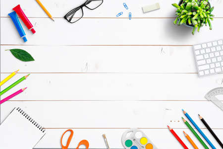 School supplies on white wooden desk. Top view, flat lay composition with copy space in the middleの写真素材