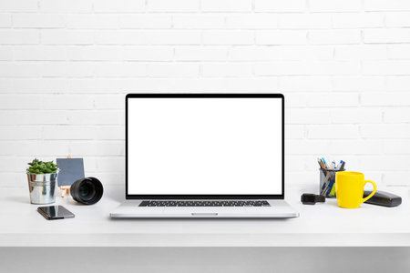 Computer display mockup on work desk. White work desk with plants, phone, box, keyboard and mouse....