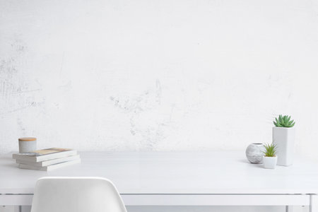 Clean white wooden desk for product promotion. Blue wall in background. Front view
