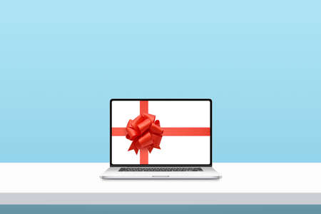 Laptop with ribbon and bow on display. Minimal concept of Christmas shoppingの写真素材