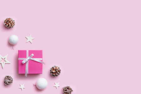 Christmas gift and decorations on pastel pink desk with copy space beside for greeting text. Top view, flat lay compositionの写真素材