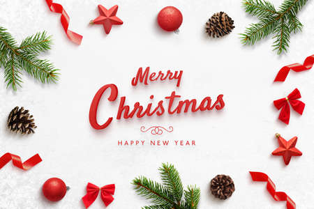 Merry Christmas and Happ New Year greeting card with Christmas derorations. Red text surrounded by tree branches, balls, stars, cones, bows.の写真素材