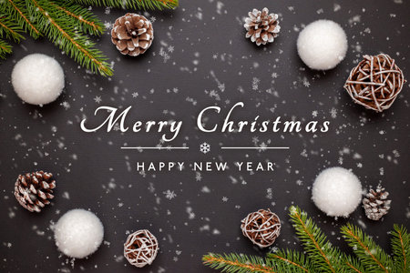 Merry Christmas and Happy New Year greeting card with decorations on black surface