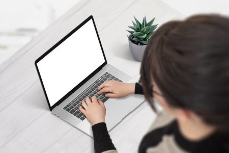 Woman work on laptop computer with isolated screen for mockup, app or web site presentation. Isometric position, over shoulder viewの写真素材