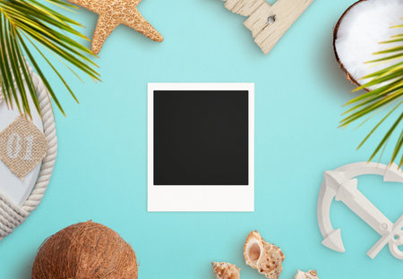 Blank old photo on blue surface surrounded by summer, beach objects. Vacation memories presentation...