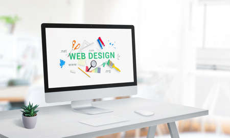 Web design studio with computer display on office desk. Creative web page with web design text surrounded by tools conceptの写真素材