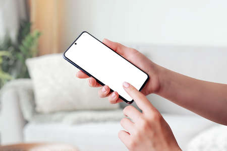 Hand holding smartphone mockup and touching screenの写真素材
