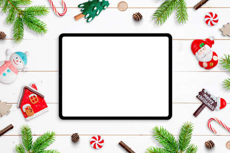 Tablet mockup on white wooden desk, surrounded by Chrismtas decorations. Top view, flat lay compositionの写真素材