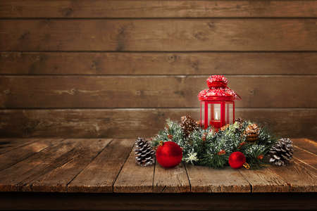 Christmas composition on old wooden table with copy space beside. Christmas tree branch with red lantern, balls and pine conesの写真素材
