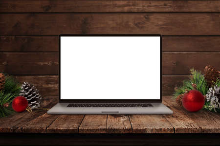 Laptop mockup on old wooden desk, surrounded by Christmas decorations. Isolated, blank display for greeting text or web page promotionの写真素材