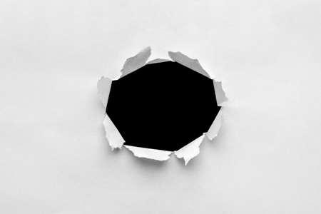 Paper sheet with black ragged holeの写真素材