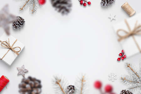 Christmas decorations fall on the white table concept. Gifts, pine, cones, red berries, tree branches, snowflakes. Top view, flat lay, greeting card conceptの写真素材