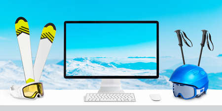Montains on computer display and background concept. Winter ski travel composition with skis, googles, poles, helmet on deskの写真素材