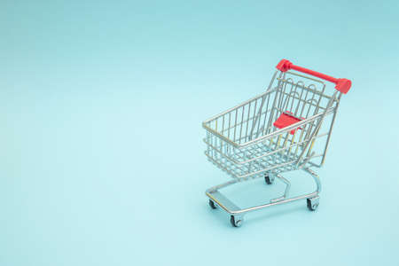 Empty shopping trolley with blue backgroundの写真素材