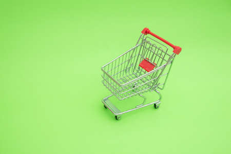 Empty shooping trolley cart on green backgroundの写真素材