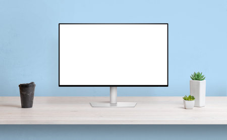 Computer display on work desk with isolated screen for web page presentation. Coffee and plants...