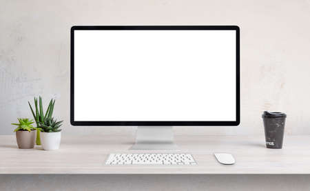 Computer display on work desk with white, isolated screen for web page presentationの写真素材