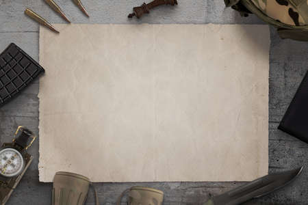Blank military map on desk surrounded by army equipmentの写真素材