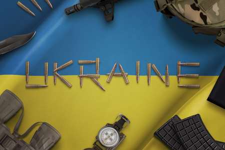 Ammunition on the Ukrainian flag concept. Russian-Ukrainian conflict. Desk with Ukrainian military equipment. Top view, flat layの写真素材