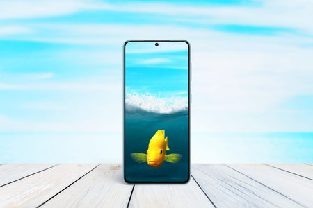 Goldfish in a mobile phone as an aquarium concept. Creative composition with sea and fish in mobile...