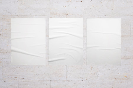 Three white posters on the interior wall. White blank crumpled texture for design presentationの写真素材