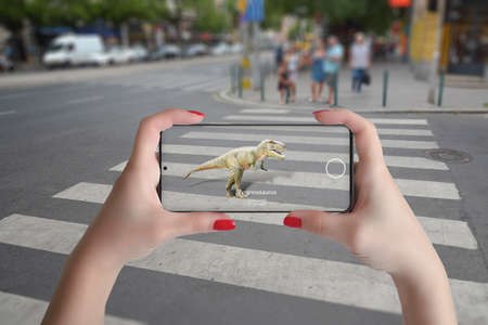 3d projection of dinosaurs on the street with smart phone and augmented reality technology conceptの写真素材