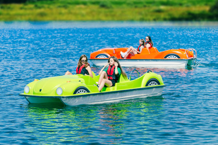 Two pedal boats on a mountain lake with teenagersの写真素材