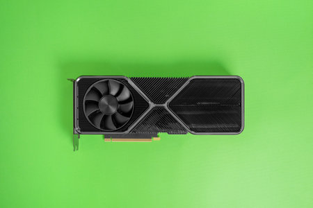 Modern graphic card on green surface. Massive radiator with two coolers. Modern gaming and rendering graphics card. Top view, flat layの写真素材