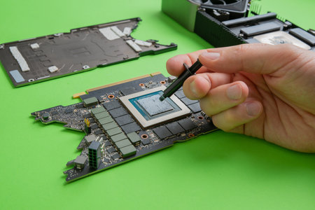 Changing the thermal paste on the graphics processor. Disassembled graphics card on the table. Old graphics card serviceの写真素材