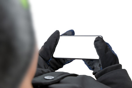 Close-up of a man's hand holding a smartphone with a white screen in horizontal position.の写真素材