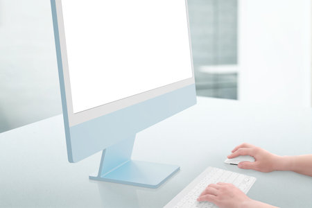 Work on computer with isoalted screen for design presentation, mockup. Hands hold the mouse and type on the keyboard. Clean office desk. Close-upの写真素材