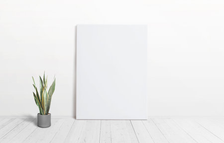 Vertical art canvas against the wall with a plant on the floor and wooden white floor. Clean surface...