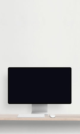 Desktop monitor with a blank screen on a desk featuring a keyboard and mouse, perfect for mockup...