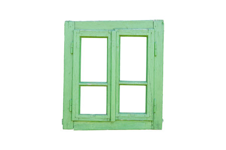 Old wooden window painted green, slightly tilted to the right, featuring four isolated panes, evoking a rustic and weathered charmの写真素材