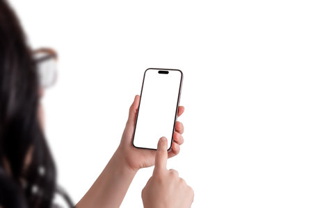Woman holding a modern smartphone in her left hand while tapping the screen with her right hand, over the shoulder view, isolated display for mockupの写真素材