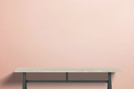 Minimalist wooden table with industrial design, bold orange backdrop, ideal for showcasing office furniture, interior design concepts, or tech product marketingの写真素材
